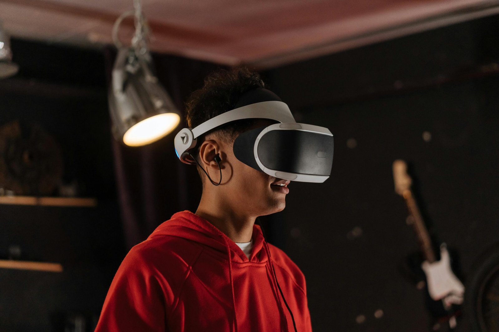 A young adult wearing a VR headset enjoys an immersive virtual reality experience indoors.